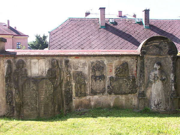 Starobylé náhrobky na hřbitovní zdi.