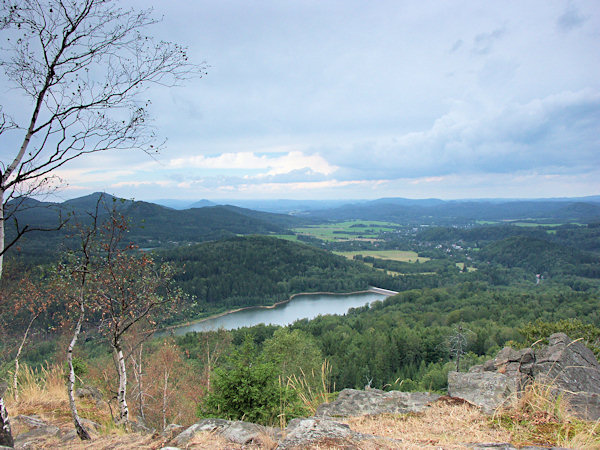 Pohled z Malého Stožce do údolí Chřibské Kamenice s přehradou Chřibská. Ve skupině kopců vlevo je nejvyšší Studenec, v pozadí vpravo od něj vyčnívá Růžovský vrch.