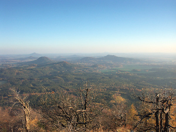 Výhled z Klíče k jihovýchodu do okolí Sloupu. Vlevo je výrazný zaoblený Ortel, před ním méně nápadný vrch Strážný, uprostřed nízký protáhlý Šišák a vpravo od něj dvojvrší Tisového vrchu se Slavíčkem. Na obzoru vlevo je Ralsko.