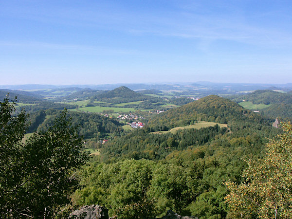 Výhled ze Středního vrchu přes Prysk na výraznou kupu Zámeckého vrchu nad Českou Kamenicí. V popředí je Břidličný vrch, pod nímž úplně vpravo vyčnívá šedé skalisko Pustého zámku.