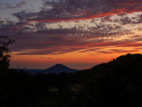Krásné večerní červánky nad Růžovským vrchem. Z malé mýtiny nedaleko Lísky je vidět pravidelný kuželovitý tvar kopce.