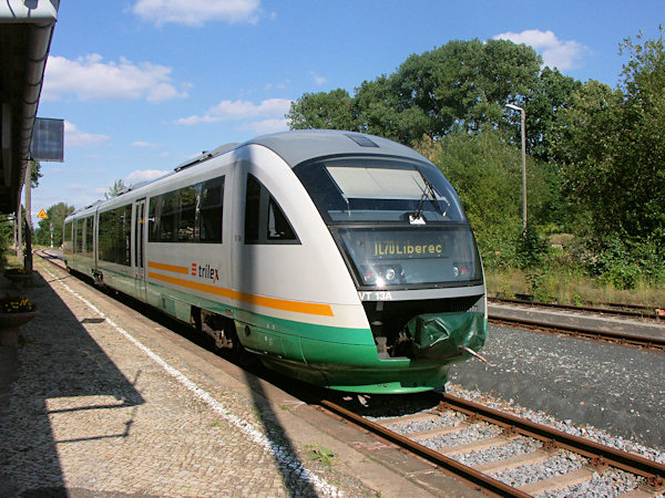 Osobní vlak ze Seifhennersdorfu do Liberce čeká ve stanici Grossschönau na křižování s vlakem do Rybniště.