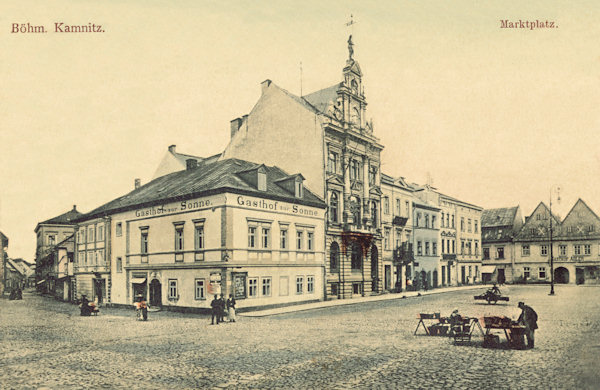 Pohlednice České Kamenice z roku 1906 zachycuje západní stranu náměstí s dnes již neexistující budovou restaurace U slunce na nároží.