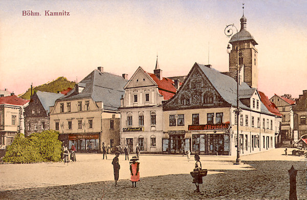 Na pohlednici České Kamenice z doby kolem roku 1915 vidíme jižní stranu náměstí s železářským obchodem J. Brandela na nároží. V pozadí vyčnívá věž kostela sv. Jakuba.