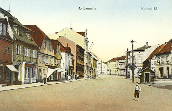 Tato pohlednice zachycuje bývalý Koňský trh na horním předměstí České Kamenice. Mezi domy na levé straně vyniká secesní budova bývalého okresního zastupitelstva z roku 1907.