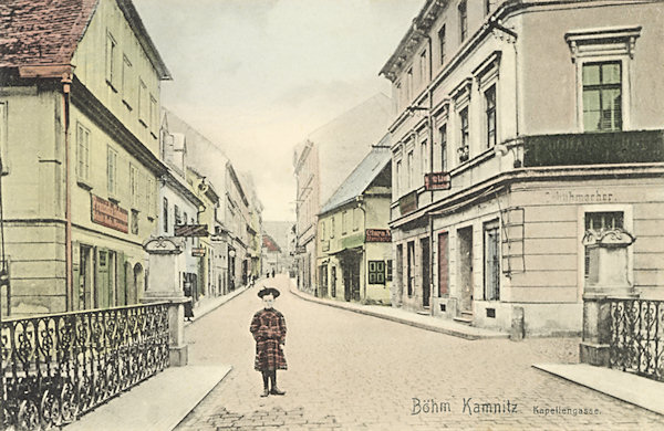 Tato pohlednice zachycuje ulici, vedoucí z náměstí k Mariánské kapli, někdy kolem roku 1910. V popředí je most přes Kamenici.
