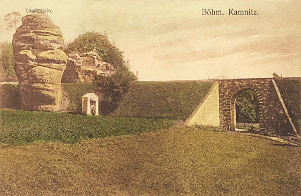Tato pohlednice zachycuje Hrnčířskou skálu, stojící těsně u náspu železniční trati na okraji Horní Kamenice.