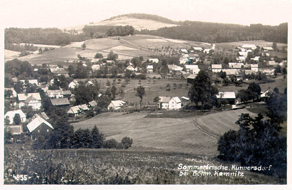 Meziválečná pohlednice zachycuje Kunratice u České Kamenice od Kunratického vrchu. V pozadí je Větrný vrch.