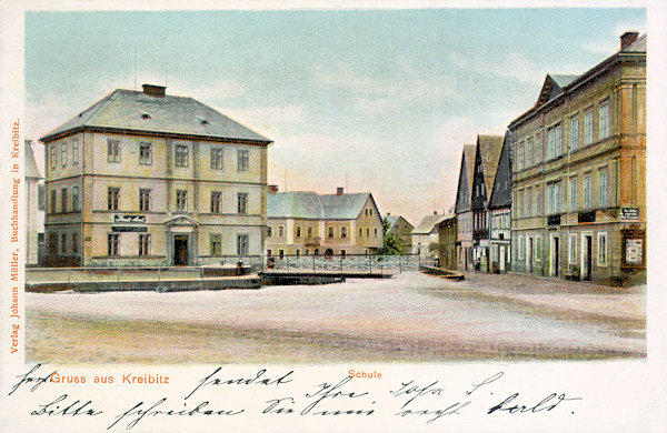 Na pohlednici z přelomu 19. a 20. století vidíme severozápadní roh náměstí s budovou, která stejně jako dnes sloužila i tehdy městskému úřadu (vlevo). V pozadí za ní stojící budova školy se v upravené podobě dochovala dodnes.