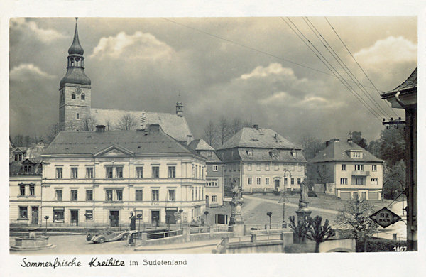Pohlednice ze 30. let 20. století zachycuje severní stranu náměstí s kostelem sv. Jiří v pozadí. Vpředu je bývalý kamenný most přes Chřibskou Kamenici.