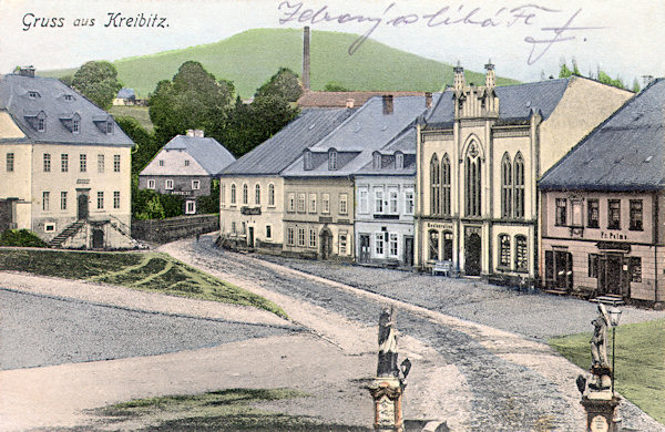Na pohlednici z počátku 20. století vidíme domy s bývalou radnicí na východní straně náměstí.