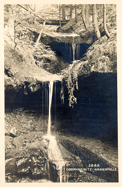 Pohlednice z roku 1929 zachycuje vodopády v zalesněném údolí u Horní Chřibské.