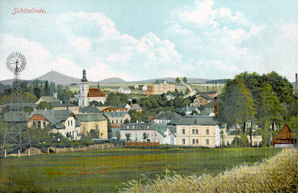 Diese Ansichtskarte zeigt das Stadtzentrum mit der Kirche der hl. Maria Magdalena von Südosten. Über der Stadt sieht man das herausragende Gebäude des Krankenhauses und am Horizont links erhebt sich der Wolfsberg (Vlčí hora) mit dem Aussichtsturm.
