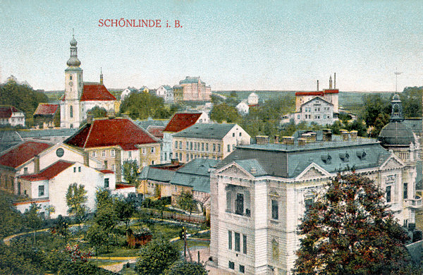 Auf dieser Ansichtskarte sieht man das Ortszentrum, dem die oberhalb des Marktplatzes stehenden Kirche der hl. Maria Magdalena dominiert. Im Vordergrunde rechts steht das 1903 erbaute repräsentative Gebäude der ehemaligen Sparkasse.