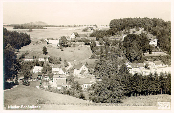 Tato pohlednice z roku 1931 zachycuje dolní část Krásné Lípy v údolí Křinice z návrší u Fibichova údolí. V pozadí vlevo je vidět vrch Dymník.