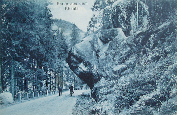 Tato pohlednice zachycuje výrazný skalní převis, vyčnívající nad údolní silničku pod Kyjovským hrádkem. Na sousední skále je dnes umístěna pamětní deska bratří Bienertů.