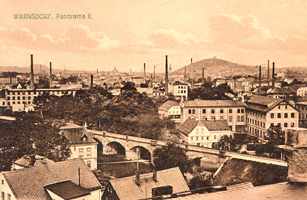Diese Ansichtskarte aus der Zeit vor dem ersten Weltkrieg zeigt die Stadt mit der über die Karlsdorferstrasse (Karlova ulice) führenden Eisenbahnbrücke im Vordergrund.