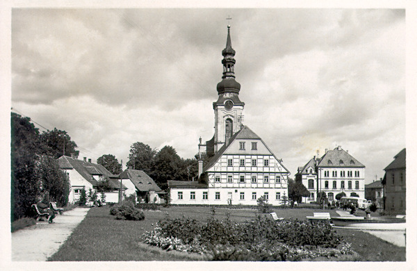 Na poválečné pohlednici vidíme bývalou rychtu, za níž vyčnívá věž kostela sv. Petra a Pavla. Vpravo od kostela stojí fara.