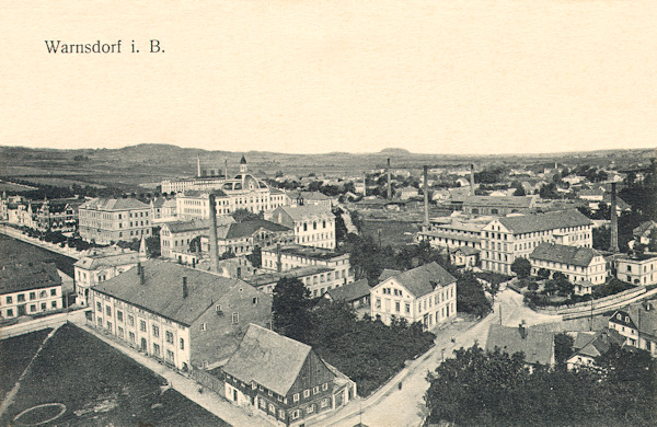 This picture postcard from the years before World War One shows the view of the northwestern part of the town from the tower of the church St Peter and Paul. In the foreground there is the park near of the market square with the great building of the „Collosseum“ and in the background the monumental building of the secondary school with its small tower.