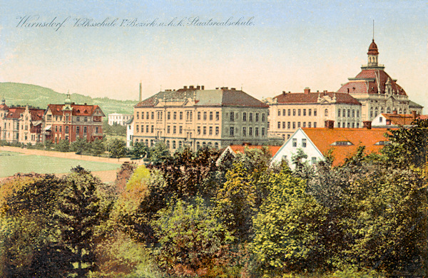 Auf dieser Ansichtskarte von um 1910 sieht man die monumentalen Gebäude der Volks- und Realschule an der Ecke der heutigen Seifertova ulice (Realschulstrasse) und der Střelecká ulice (Schützengasse).