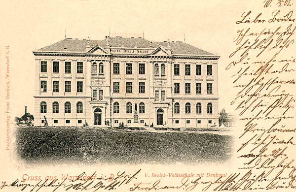 Auf dieser Ansichtskarte aus der Wende des 19. und 20. Jahrhunderts sieht man das Gebäude der Volksschule in der Realschulgasse (heute: Seifertova ulice). Vor der Schule stand damals das Denkmal Kaiser Franz Josef I.