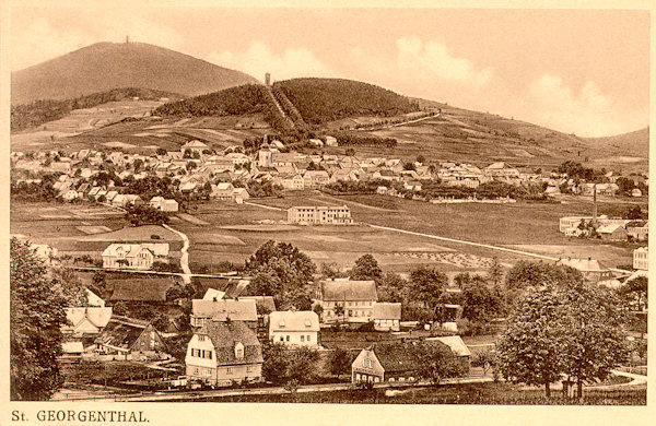 This picture postcard shows the town of Jiřetín at the foot of the Křížová hora hill. In the background there is the Jedlová hill, the houses in the foreground, however, belong already to the village Dolní Podluží.