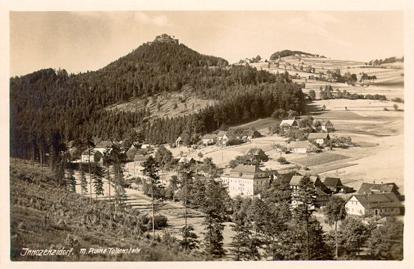 This picture postcard from 1929 shows the village Lesné under the Tolštejn rock cliff. In the still standing building in the centre of the picture in former times was the inn „Zum Ritterhof“ (=Knight's court).