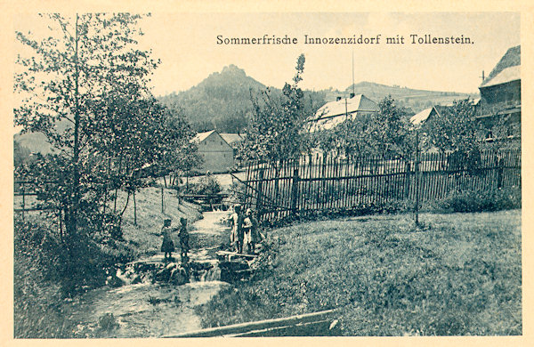 On this picture postcard from the first half of the 20th century you see the Lesenský potok brook on the bank of which formerly stood the Buschmühle mill. In the background are the ruins of the Tolštejn castle.