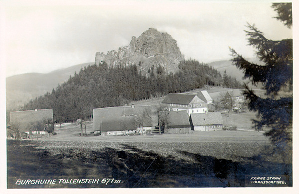 Diese Ansichtskarte aus dem Jahr 1926 zeigt die Ruine der Burg Tolštejn (Tollenstein) und eine Häusergruppe an der alten Strasse im Sattel unter der Burg.