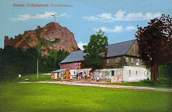 This postcard shows the rocky cliff with the look-out platform and the ruins of the Tolštejn castle. In the foreground there is the former house of the local authority and inn of which at present there only the basements remain.