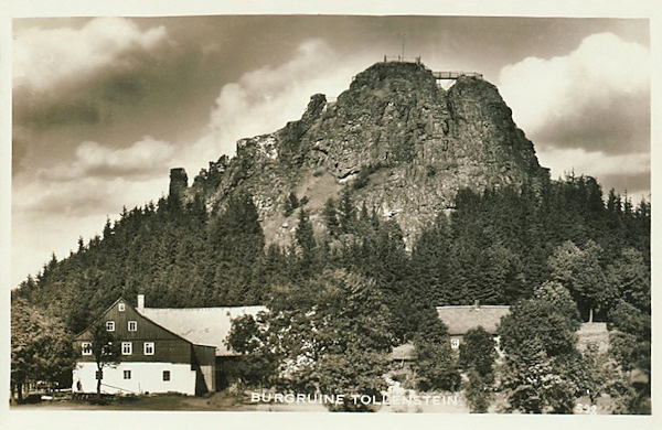 This picture postcard shows the castle rock with the lookout platform on its summit and the old office of the village magistrate on its foot.