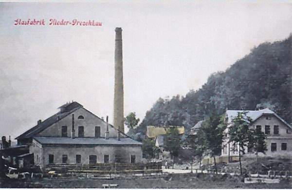 Nedatovaná pohlednice zachycuje sklářskou huť v dolní části obce někdy ve 20. letech 20. století.