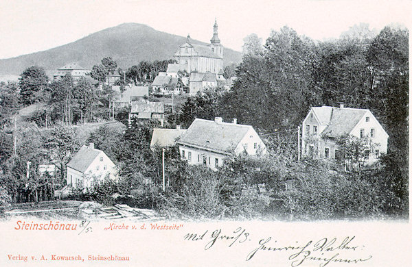 Na pohlednici z roku 1908 vidíme kostel sv. Jana Křtitele ze západní strany od hlavní silnice do České Kamenice. V pozadí je Šenovský vrch.