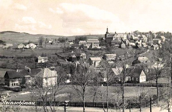Tato meziválečná pohlednice zachycuje střední část města s kostelem sv. Jana Křtitele z oken nové školní budovy, postavené u hlavní silnice do České Kamenice.