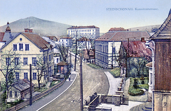 Pohlednice z roku 1913 zachycuje hlavní ulici od České Kamenice. V pozadí je vidět výstavná budova školy a na obzoru za ní vyčnívá Šenovský vrch.