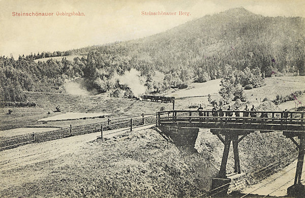 Na této pohlednici je zachycen velký oblouk trati za dolním nádražím. V pozadí vidíme Šenovský vrch.