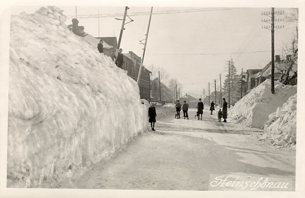 Na této pohlednici z února 1924 vidíme sněhové bariéry u bývalého železničního přejezdu na staré hlavní silnici z Práchně.