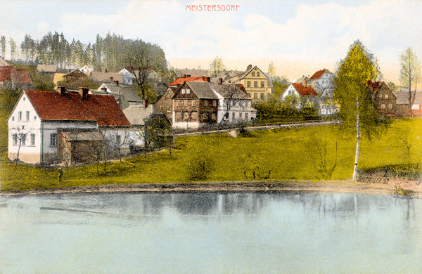 Tato nedatovaná pohlednice zachycuje horní část Mistrovic na svahu návrší „Scheibe“ nad rybníkem.
