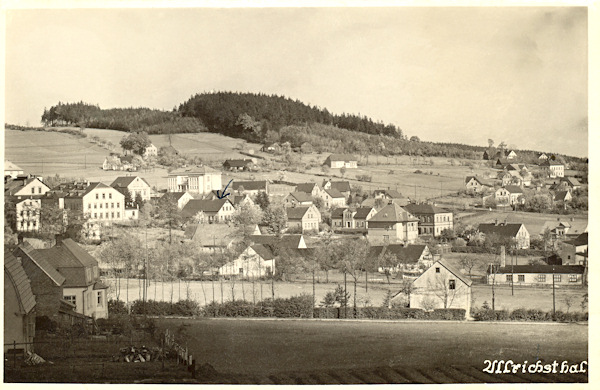 Tato pohlednice zachycuje Nový Oldřichov se zalesněnou Krásnou horou. Zcela vlevo jsou vidět objekty bývalé sklárny a vpravo od nich v pozadí je světlá budova školy.