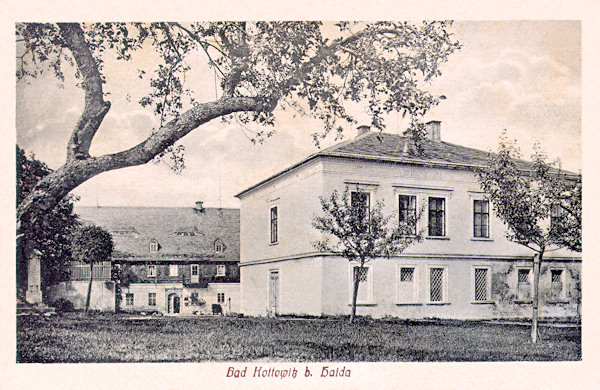 Na pohlednici z doby kolem roku 1920 vidíme novější lázeňskou budovu s hostinskými pokoji, postavenou po roce 1870. V pozadí je původní Helzelův hostinec.