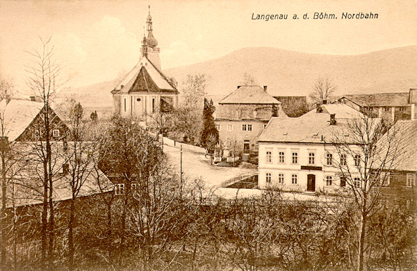 Auf dieser Ansichtskarte von um 1910 sieht man die Ortsmitte von Skalice (Langenau) mit der der hl Anna geweihten Kirche, rechts von ihr steht die Pfarrei und vor ihr steht die Gaststätte „Zur Sonne“.