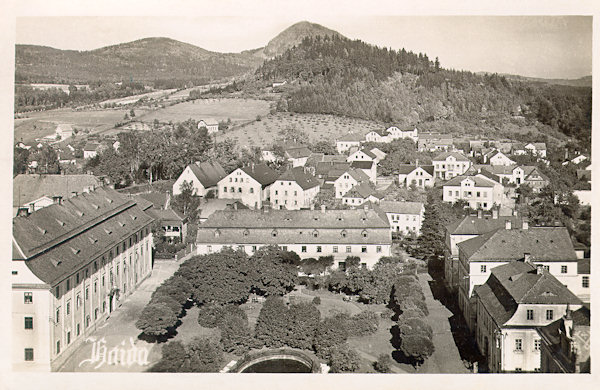 On this picture postcard we see the northern part of the main square of Nový Bor witn the adjoining part of Arnultovice under the woody Borský vrch-hill, and on the background behind of it protrudes the peak of the Klíč-hill.
