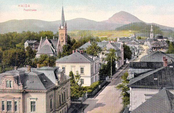 On this picture postcard from about 1905 the then Poststreet is shown from the south. In the foreground there is the Protestant church built in 1902, in the background the tower of the church Assumptioon of the Virgin and the horizon behind the town is closed by the monumental cone of the Klíč-hill.