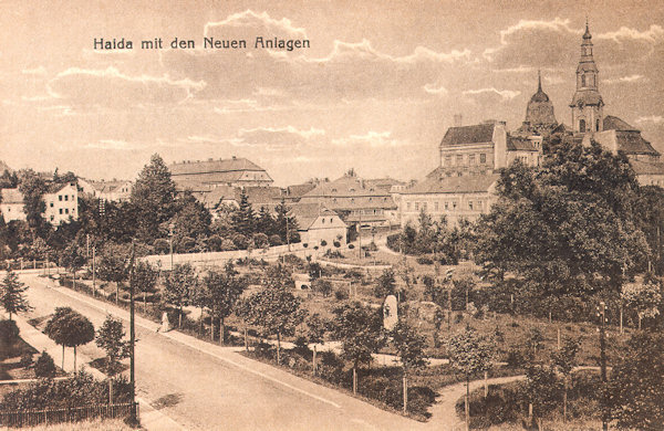 On this picture postcard from the years before 1920 a part of the town park founded in 1910-1911 is shown. In the foreground there is the Smetanova-ulice-street, in the background the houses at the market place with the dominating savings bank building and the church Asumption of the Virgin.