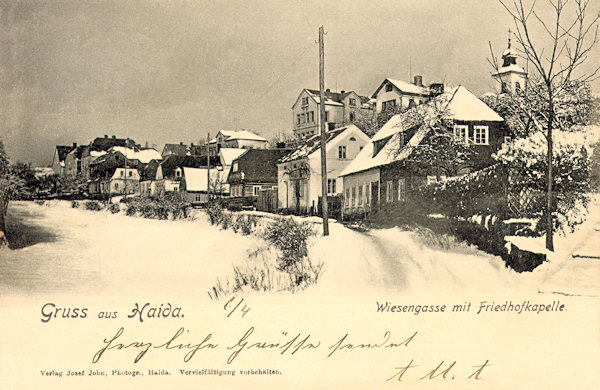 This picture postcard from 1920 shows the then Wiesengasse named street (at present Winterova ulice) which till present days remained almost unchanged. In the background the tower of the cemetery chapel is seen.