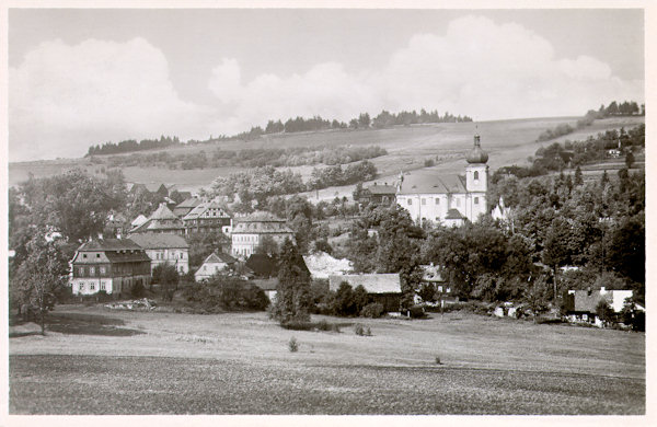Tato pohlednice zachycuje o něco podrobněji střed obce s kostelem Nejsvětější Trojice.