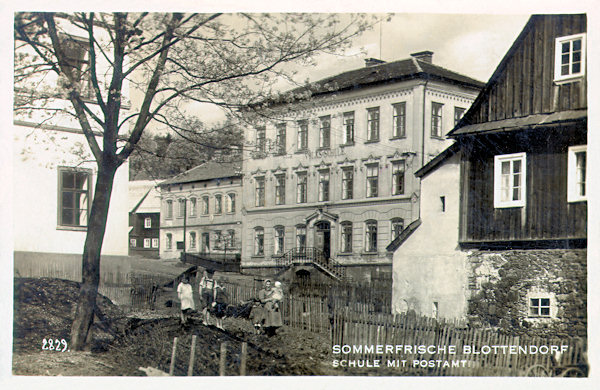 Auf dieser Ansichtskarte aus den 30er Jahren des 20. Jahrhunderts sieht man das Monumentalgebäude der Volksschule und hinter ihm das teilweise verdeckte Postamt.