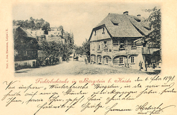 Diese Ansichstkarte von 1898 zeigt das ehemalige Gasthaus Fichtelschenke an der Strasse nach Svojkov (Schwoika). Im Hintergrund sieht man den Felsblock des Poustevnický kámen (Einsiedlerstein).