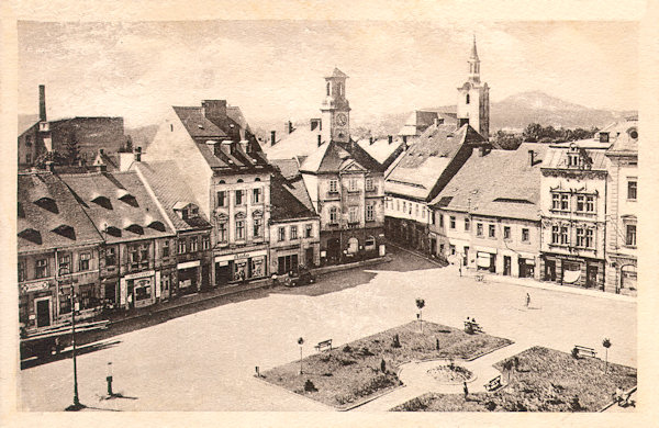 This picture postcard shows the southweatern part of the market place with the town hall around of 1947. The place of the demolished seignorial house had already been adapted to a small park.