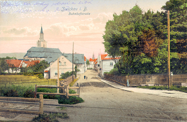 Diese Ansichtskarte von 1914 zeigt die nach Sloup (Bürgstein) führende ehemals verträumte Bahnhofstraße (heute Čs. armády). 1970 wurde sie aber unmittelbar hinter den letzten Häusern von der neuen Umgehungsstrasse überquert, während die im Vordergrund sichtbare, am 1. September 1886 eröffnete Lokalbahnstrecke aus Svor (Röhrsdorf) im Jahr 1973 aufgelasssen worden ist.
